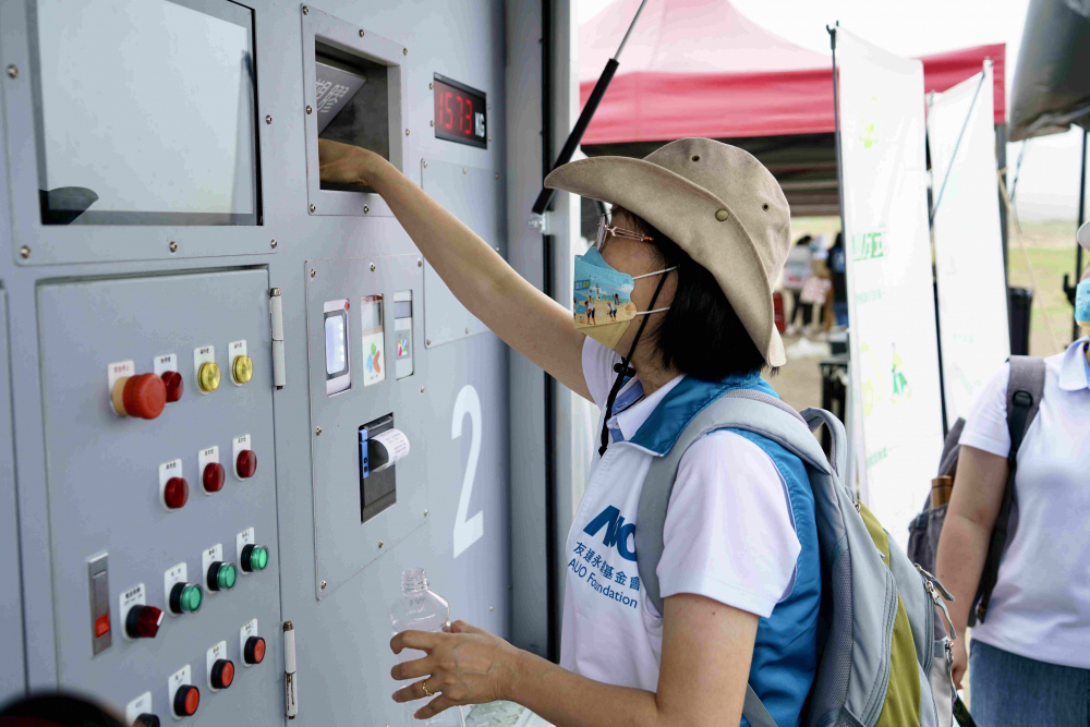 志工們將拾起的寶特瓶投入「好歸塑專車」，讓廢棄塑料空瓶可以直接粉碎、縮小體積，未來將可再製成購物袋、寶特衣、悠遊卡等生活用品